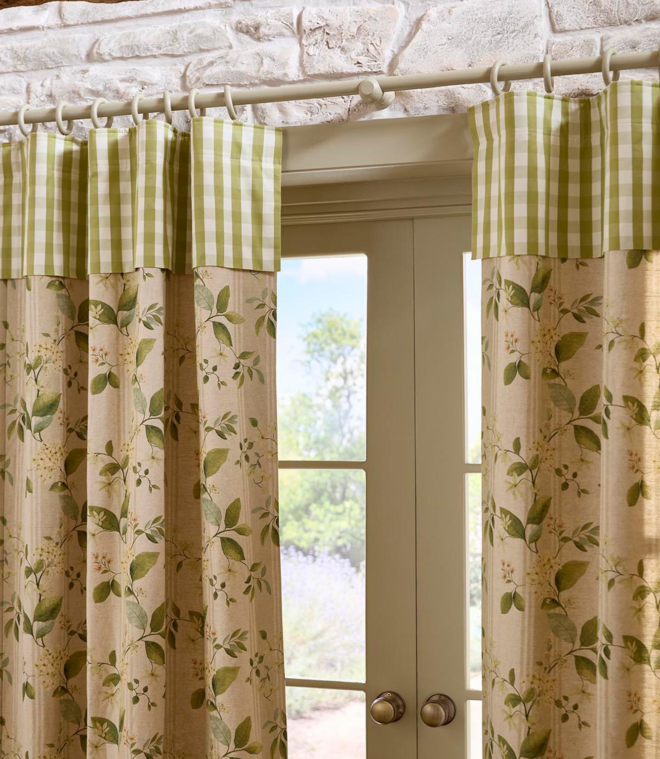 Full view of patterned curtains framing glazed double doors, combining a leafy botanical fabric with a contrasting green gingham top border for a classic country finish.