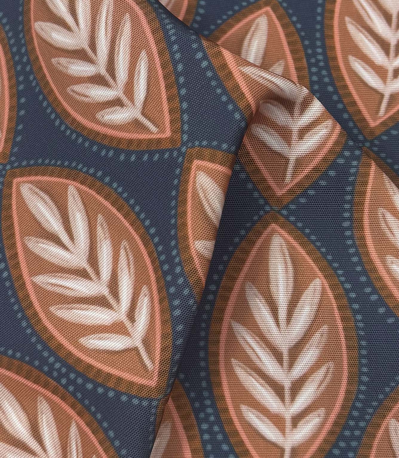 Draped Amber Canopy outdoor fabric displaying textured woven foliage design in muted coral, brown, ivory, and deep blue tones.