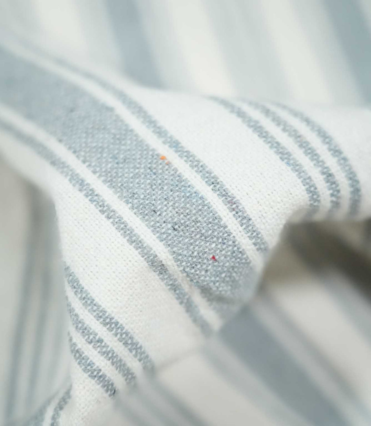 Close-up of Aldsworth Stripe Haze fabric showing soft blue-grey and white stripes with a textured woven finish and fine stripe detailing.