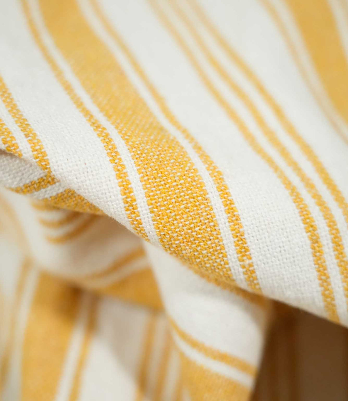 Detailed close-up of Aldsworth Stripe Ochre fabric showing the textured weave, golden yellow stripes and contrasting off-white background.