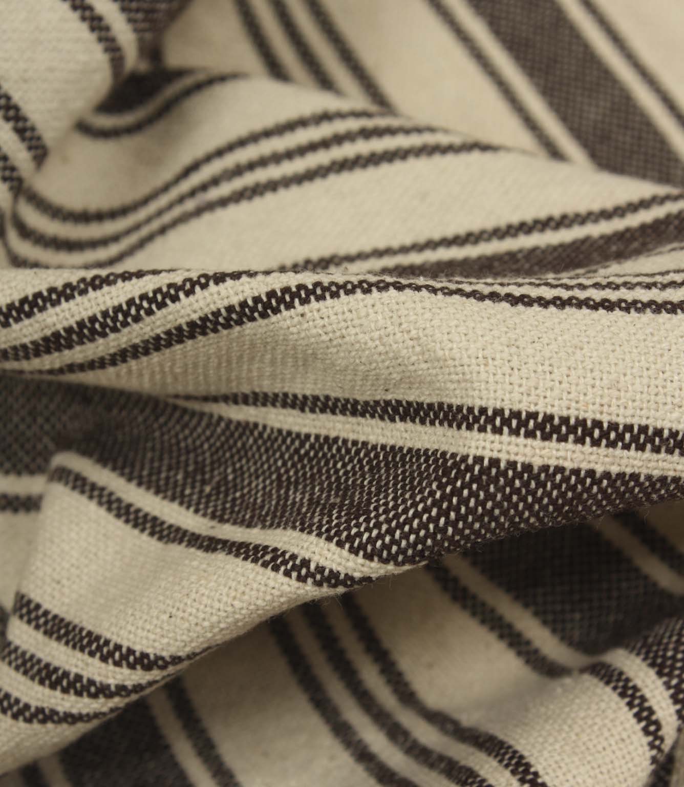 Macro close-up of cream and brown striped woven fabric showing the tactile texture and fine stripe detailing.