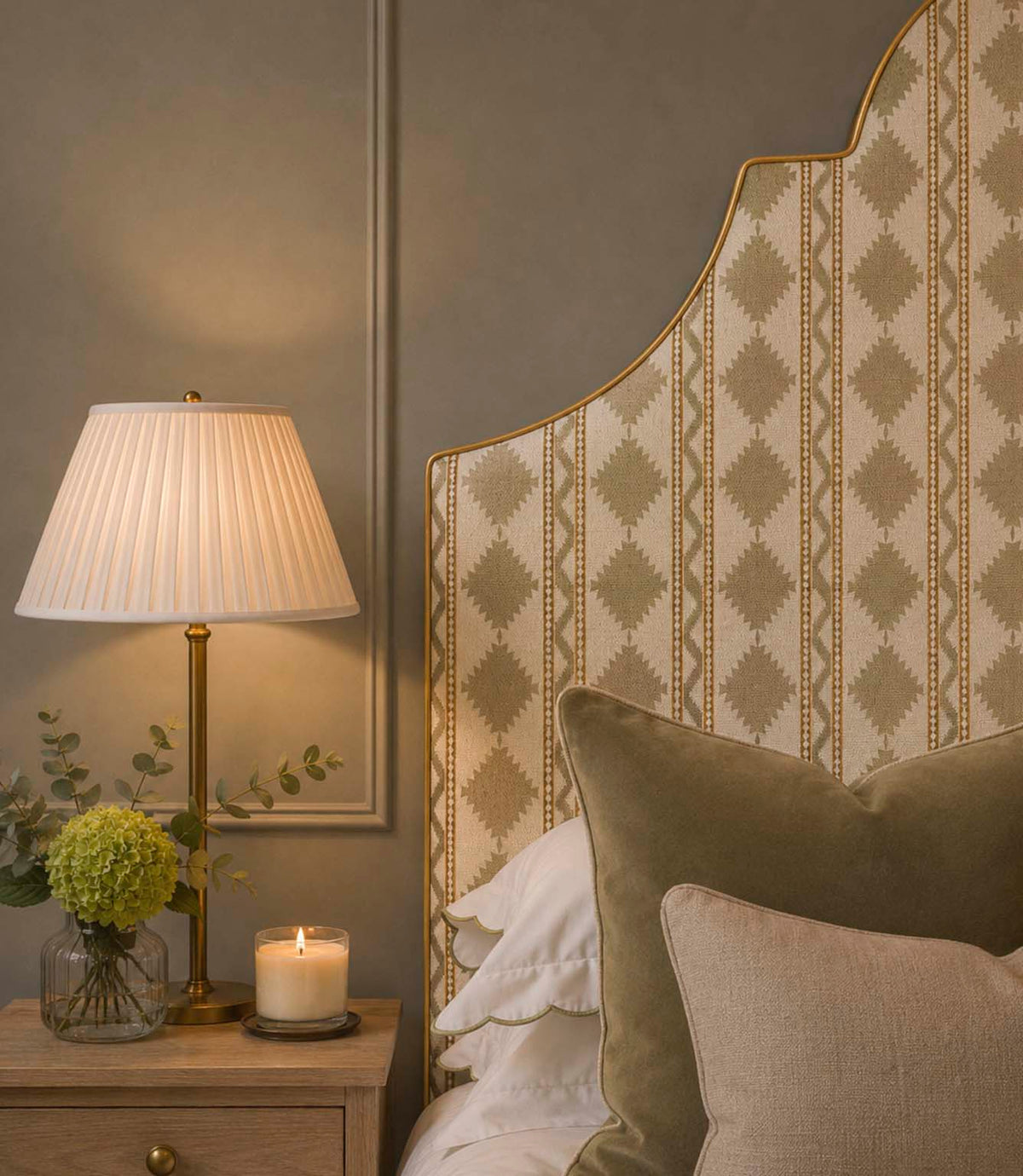 Arlo Geo Mushroom fabric upholstered headboard featuring a soft neutral geometric floral stripe pattern on a natural background with golden piping, styled with olive velvet cushions and a bedside table.