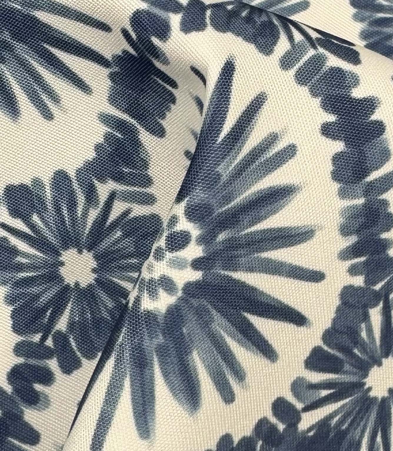 Draped Atlantic Flower outdoor upholstery fabric showing oversized blue floral motifs with soft painterly detailing on a natural ivory background.