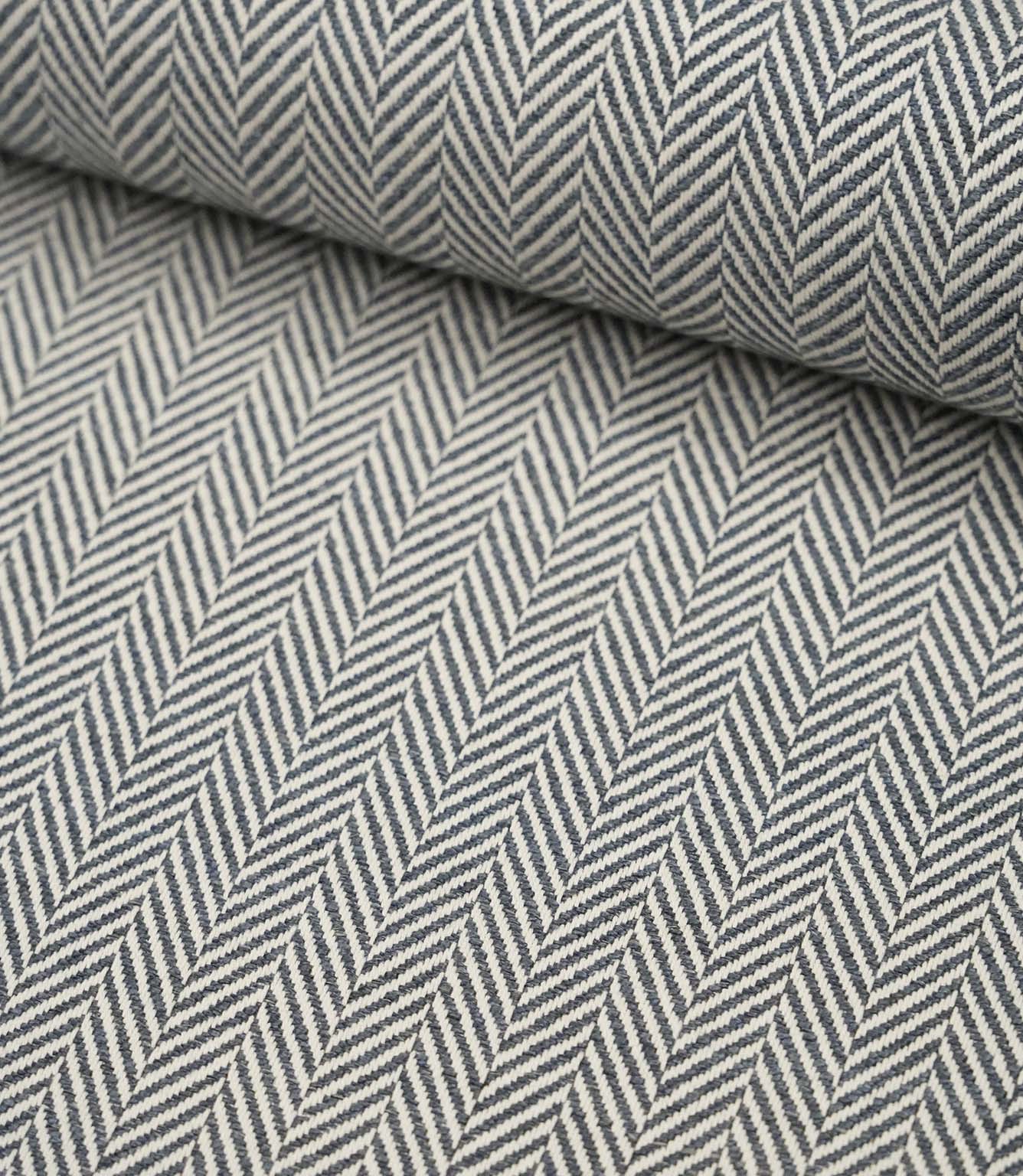Rolled Bampton Ink upholstery fabric showcasing the woven herringbone chevron pattern in ink blue and ivory, perfect for curtains, blinds and upholstery projects.