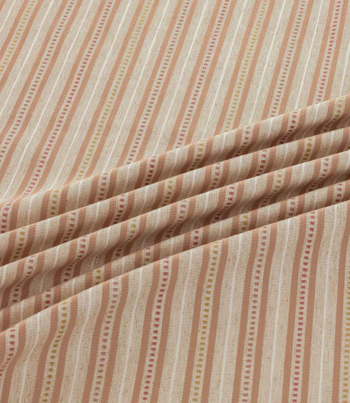 Brookhaven Coralee fabric draped in gentle folds, highlighting its coral, terracotta and mustard striped design, dotted detailing and textured surface.