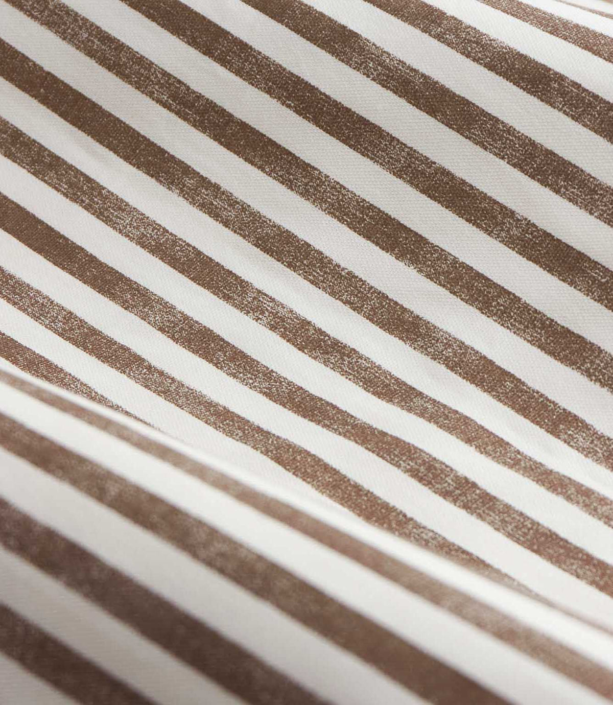 Close-up of brown and cream striped curtain fabric arranged in soft folds, showing the woven texture and slightly irregular printed vertical stripes.