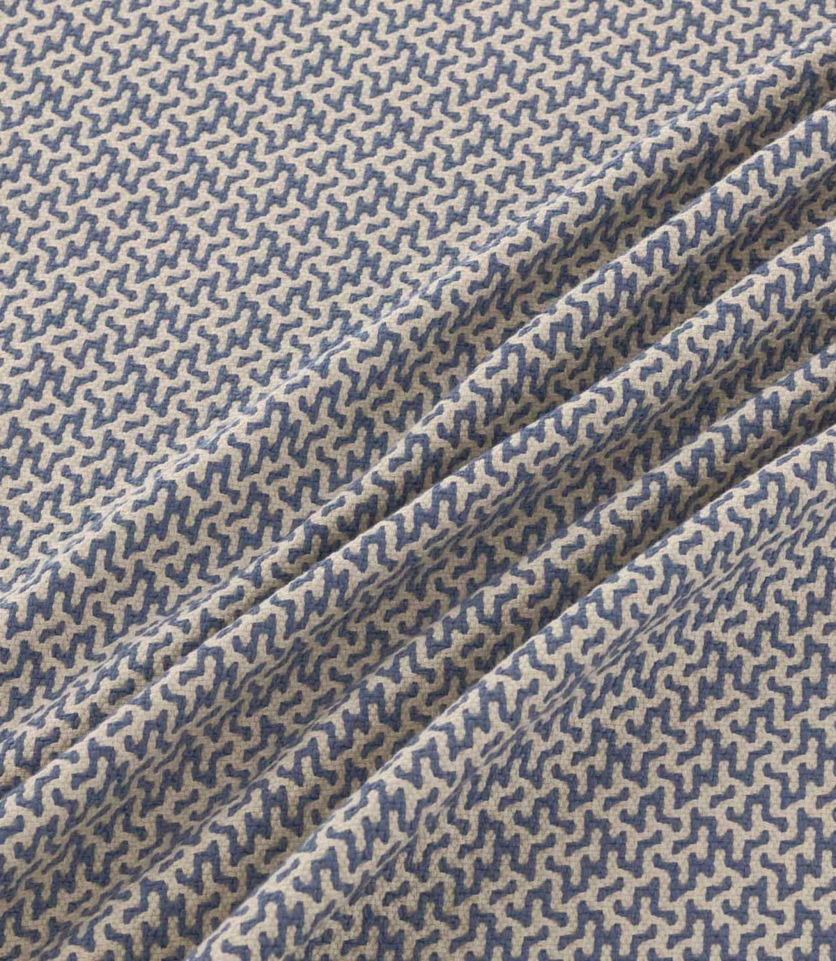 Horton Nautica blue and cream geometric fabric gathered into soft folds, displaying its detailed repeating pattern and textured woven finish.
