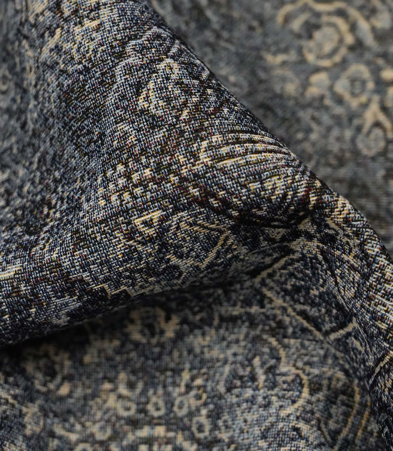 Close-up of blue Keshan tapestry upholstery fabric showing the detailed woven texture and distressed Persian-style motif.