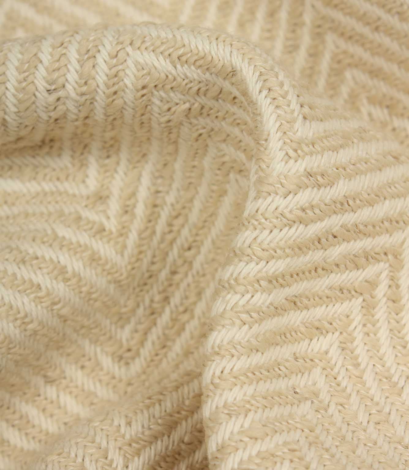 Close-up of beige fabric with a herringbone pattern