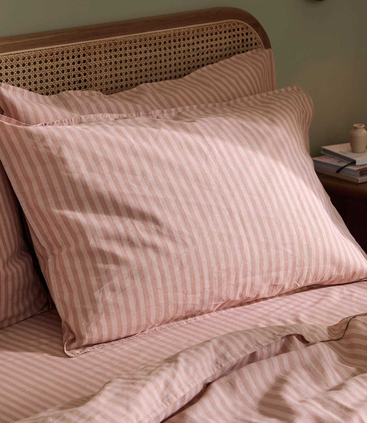 Close-up of a Marlow Stripe pillowcase in blush pink and rose, showing the fine striped design and softly relaxed fabric finish.