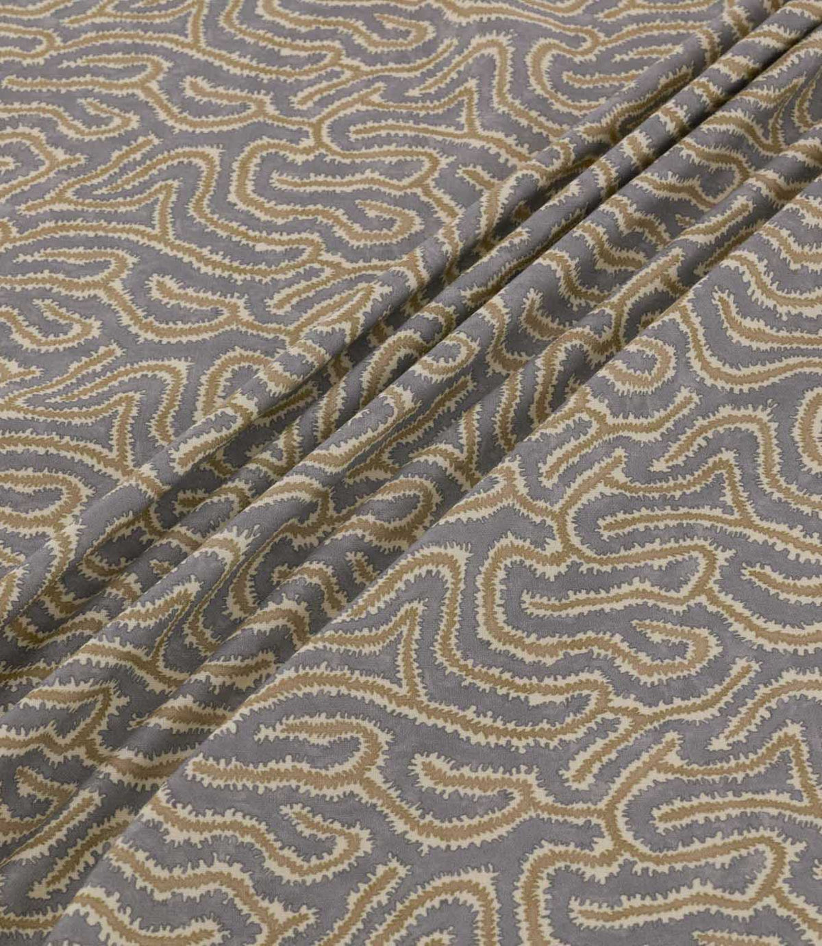 Noyack Rockport fabric arranged in soft, flowing folds, showcasing its muted slate grey background and distinctive abstract pattern of winding taupe and cream lines. The close-up highlights the intricate feathered edges, woven texture and natural drape of the fabric.