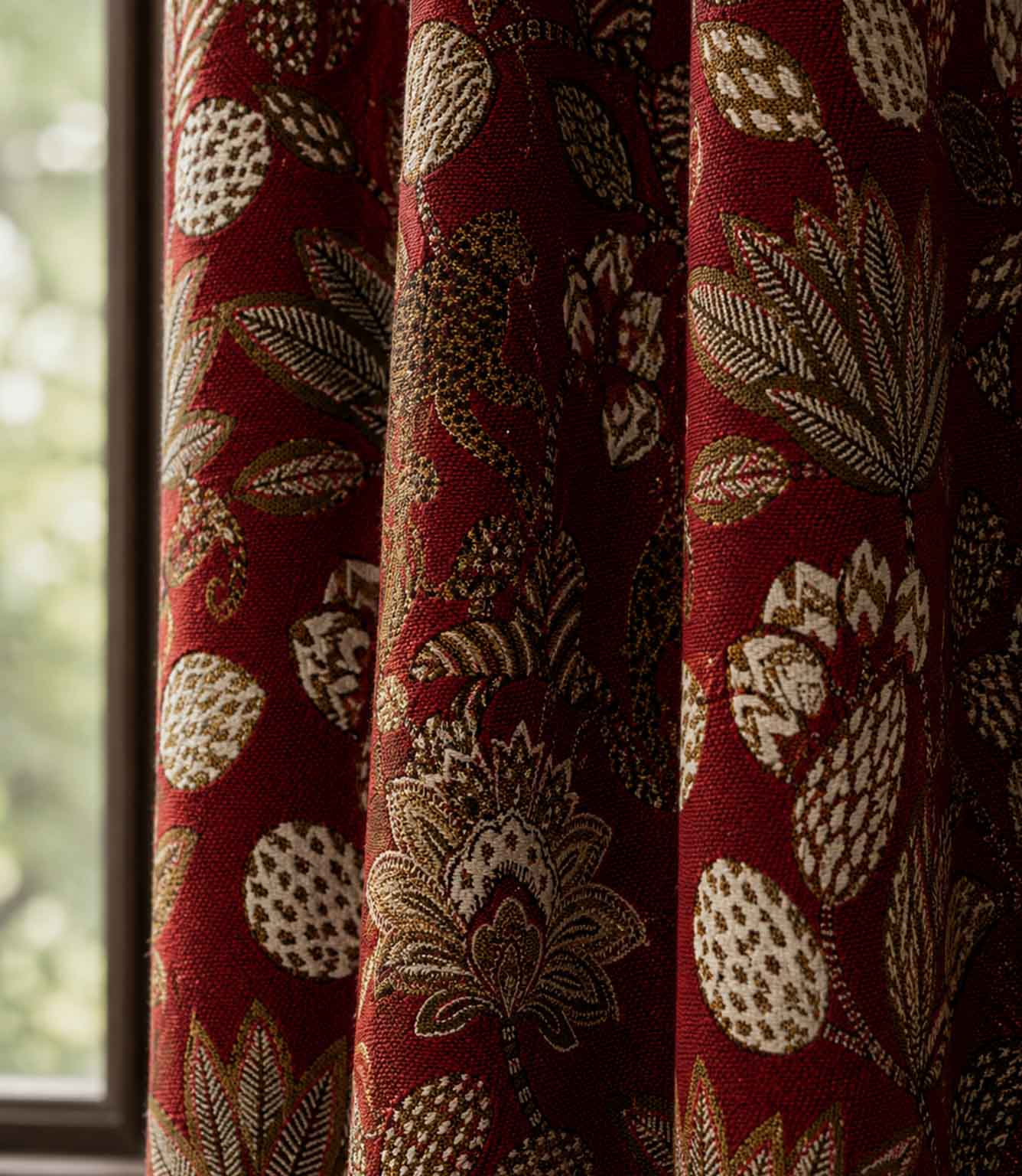 Red curtain with leaf pattern in front of a window