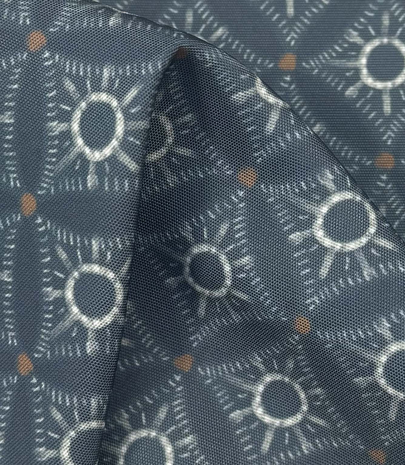 Draped Solstice Halo outdoor fabric showing a textured geometric pattern in dusty blue, ivory, and burnt orange shades.
