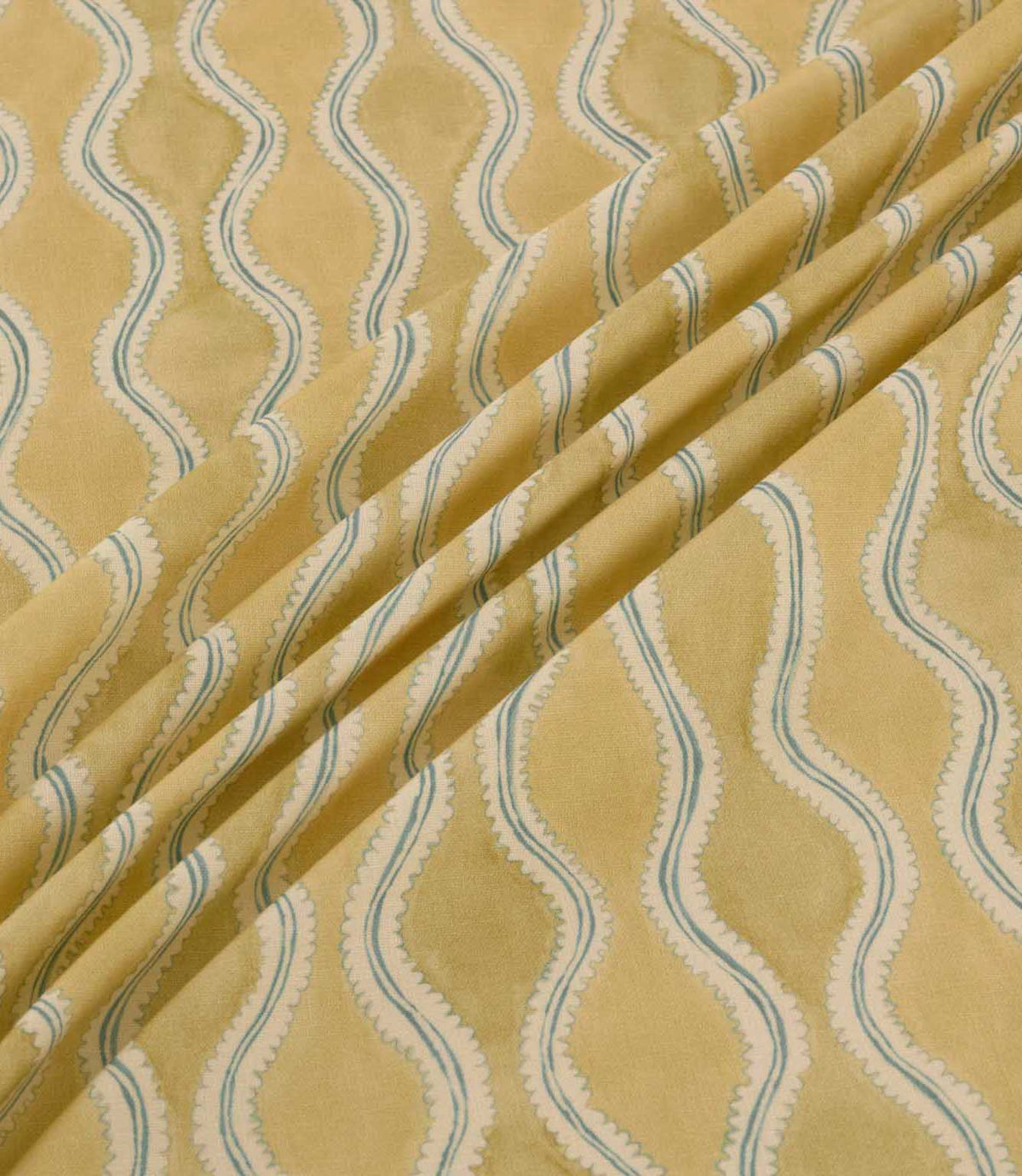 Wading Sunkiss fabric arranged in soft diagonal folds, showcasing its flowing teal blue and cream wavy stripe pattern, scalloped edges and golden yellow textured background, highlighting the fabric's drape and decorative design.