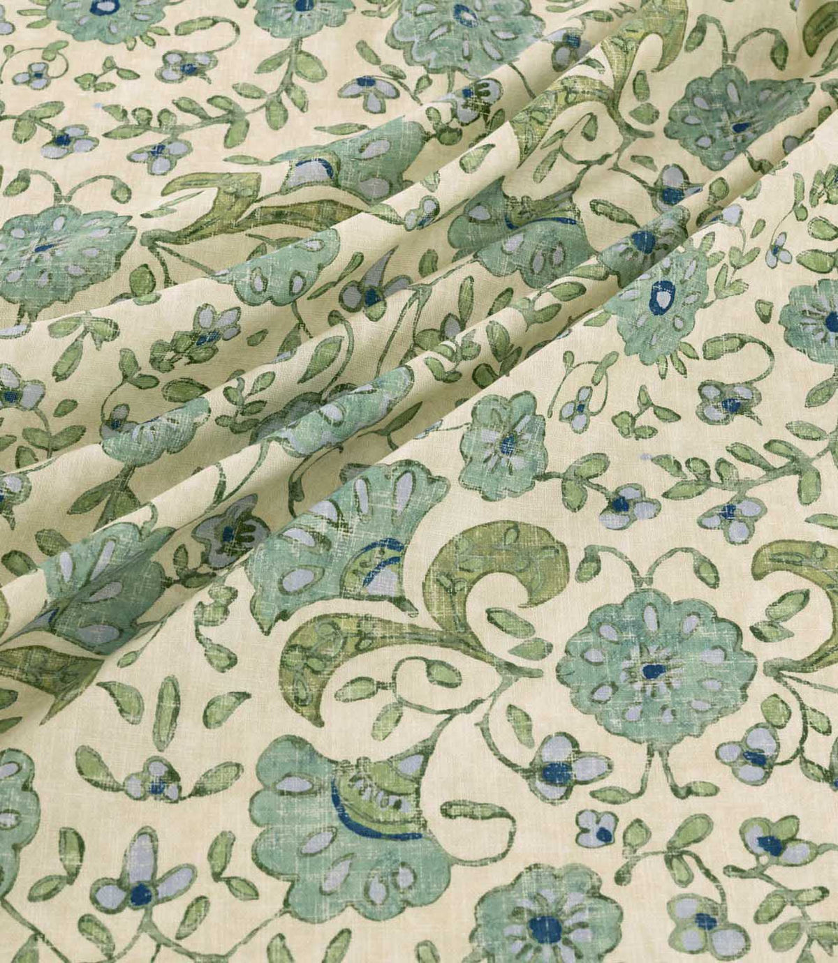 Wainscott Saltwater floral curtain and upholstery fabric arranged in soft diagonal folds, showcasing its traditional botanical pattern of sage green and aqua blue flowers, deep blue accents, scrolling olive green foliage and delicate floral sprigs on a warm ivory background, with a visible woven texture and natural drape.
