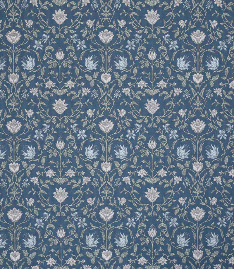 Traditional floral and foliage fabric featuring an intricate symmetrical pattern in soft ivory and pale blue motifs set against a rich denim blue background, with delicate trailing stems and stylised blossoms.