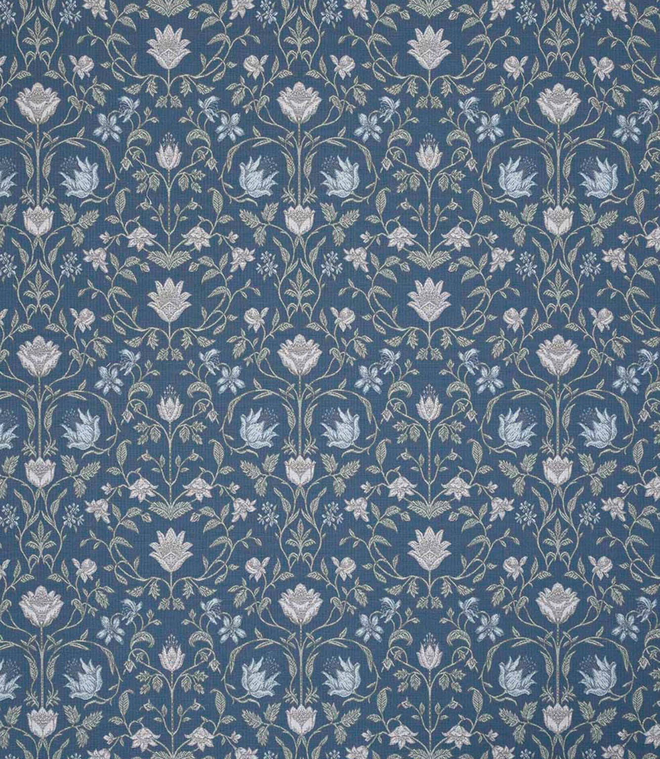 Traditional floral and foliage fabric featuring an intricate symmetrical pattern in soft ivory and pale blue motifs set against a rich denim blue background, with delicate trailing stems and stylised blossoms.
