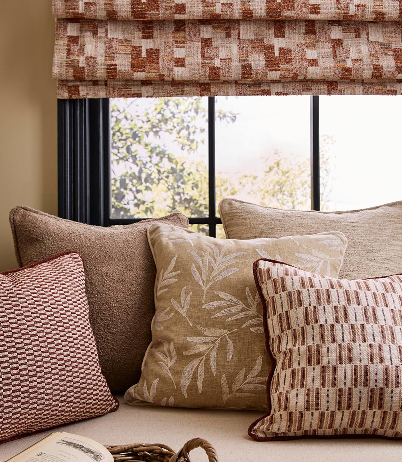 Living room setting with upholstered cushions in terracotta stripe fabric, paired with soft neutrals and a coordinating Roman blind for a cohesive, contemporary scheme.