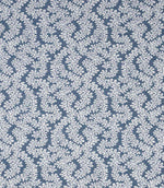 Detailed view of contemporary foliage upholstery fabric in muted blue and ivory tones, showing a natural woven texture and intricate leaf design.