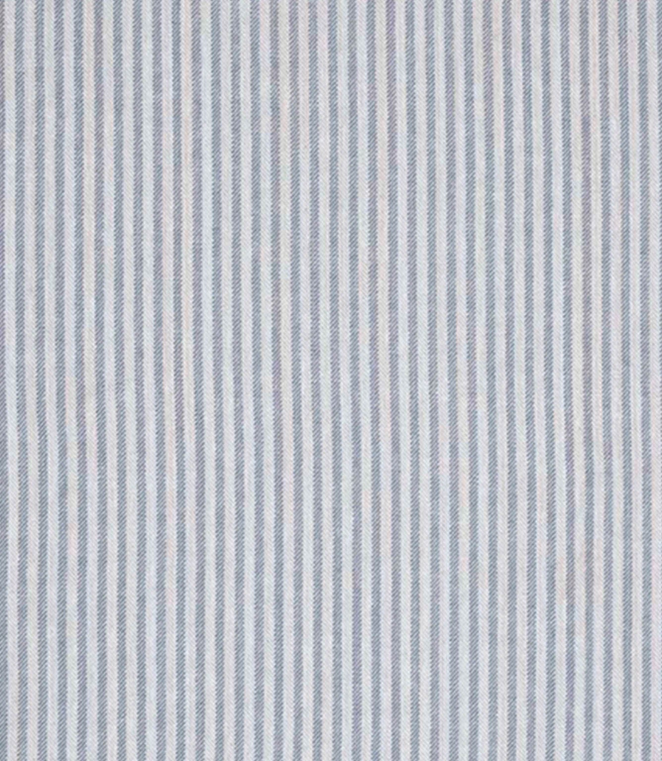 Woven ticking stripe fabric with fine vertical lines in soft blue and neutral tones, set against a light background with a subtle herringbone texture and a calm, tailored appearance.