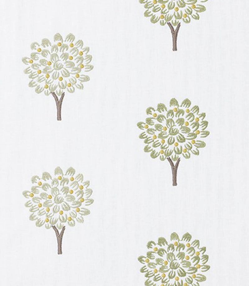 Close-up of embroidered tree motif fabric showing delicate leaf detailing in muted green with small yellow accents and a soft off-white ground, highlighting the fine stitchwork.