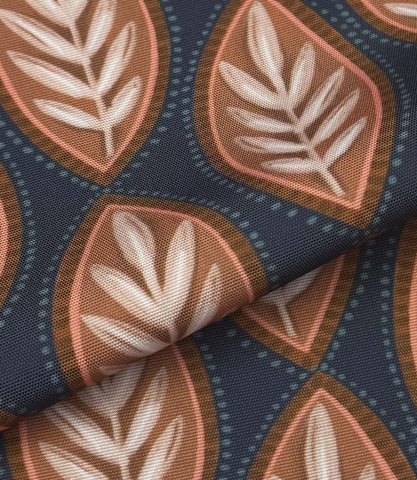 Folded Amber Canopy outdoor upholstery fabric with stylised leaf pattern in warm terracotta, soft pink, and ivory tones against a dark blue base.