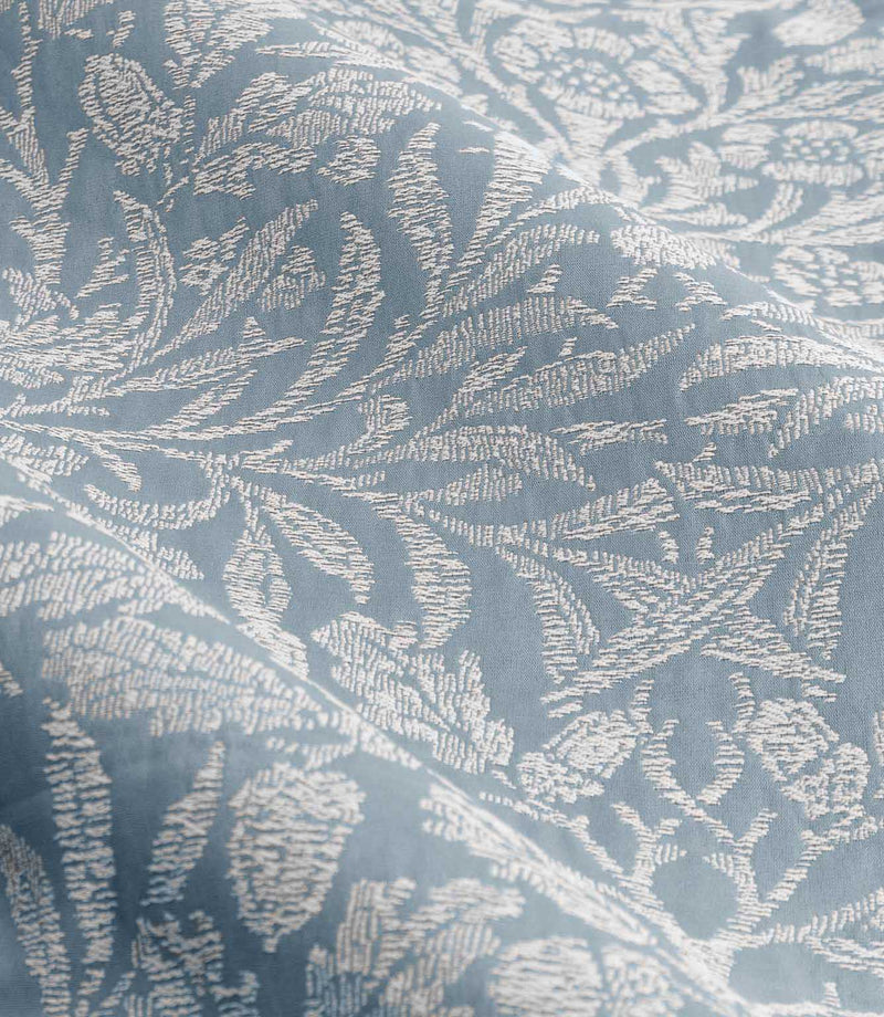 Detailed close-up of Morris & Co Acorn jacquard fabric in Wedgwood blue and off-white, showing the textured weave and traditional botanical pattern.