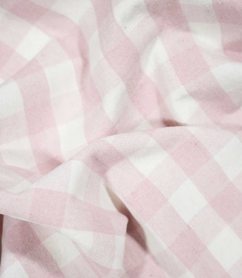 Aldsworth Check Pink fabric arranged in soft, flowing folds, showcasing its blush pink and white check pattern and natural drape.