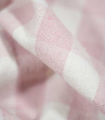 Detailed close-up of Aldsworth Check Pink fabric highlighting the fine woven texture and contrasting blush pink and white checked design.