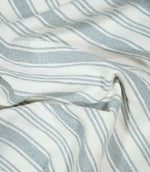 Aldsworth Stripe Haze fabric arranged in soft folds, showcasing its classic blue-grey and white striped design and natural woven texture.