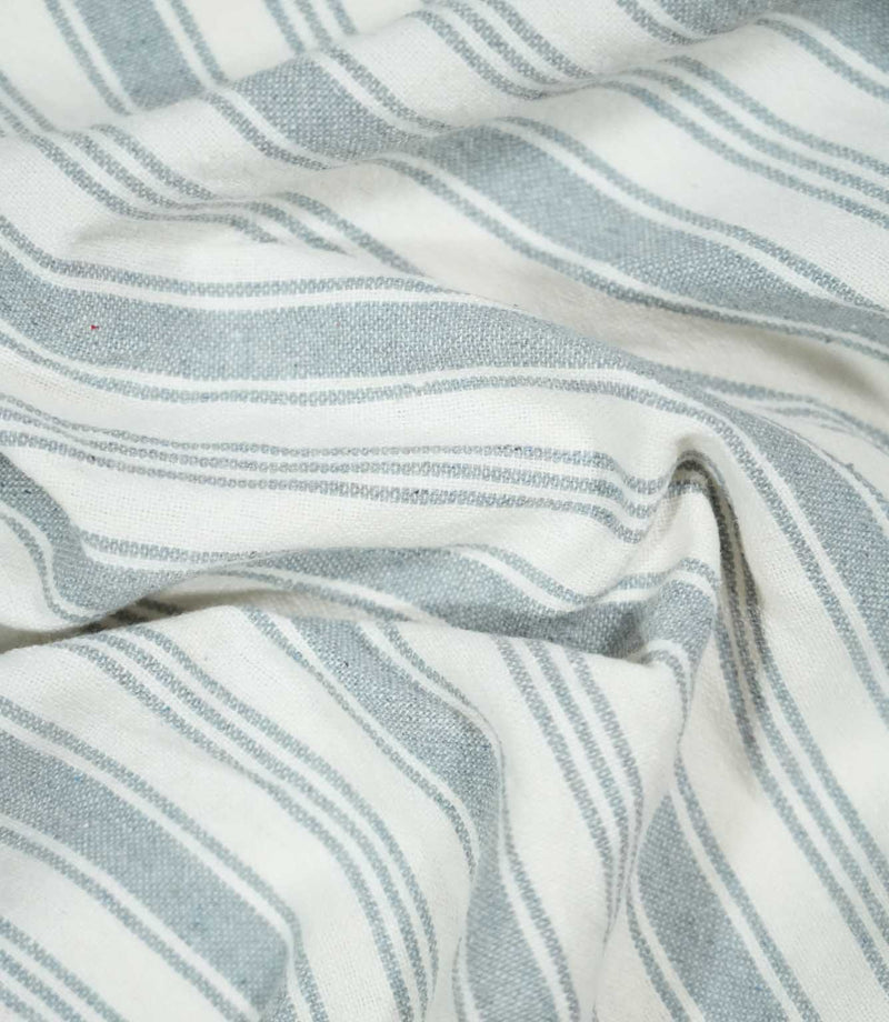 Aldsworth Stripe Haze fabric arranged in soft folds, showcasing its classic blue-grey and white striped design and natural woven texture.