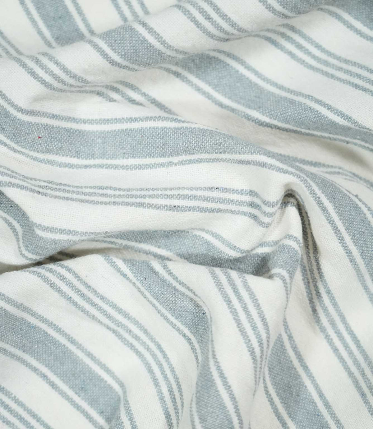 Aldsworth Stripe Haze fabric arranged in soft folds, showcasing its classic blue-grey and white striped design and natural woven texture.