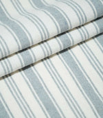 Folded Aldsworth Stripe Haze fabric featuring alternating wide and narrow blue-grey stripes on a white background with a textured weave.