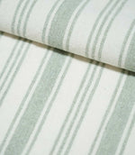 Aldsworth Stripe Mint fabric arranged in layered folds, displaying its alternating wide and narrow green stripes against a white background.
