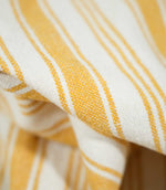 Detailed close-up of Aldsworth Stripe Ochre fabric showing the textured weave, golden yellow stripes and contrasting off-white background.