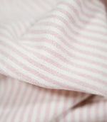 Close-up of Aldsworth Ticking Pink striped fabric draped in a soft fold, highlighting the delicate pink and white stripes and textured weave.