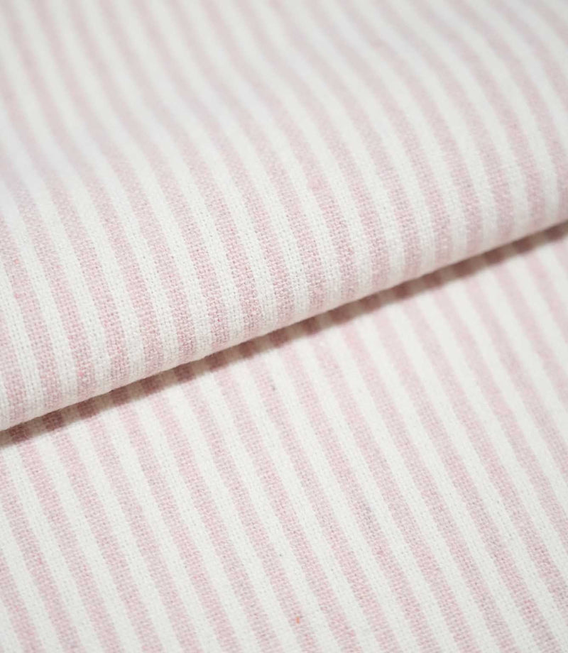 Folded Aldsworth Ticking Pink fabric showing the repeating narrow pink and off-white stripe pattern and detailed woven texture.