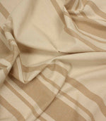Soft draped striped fabric in beige and cream showing natural movement and texture.