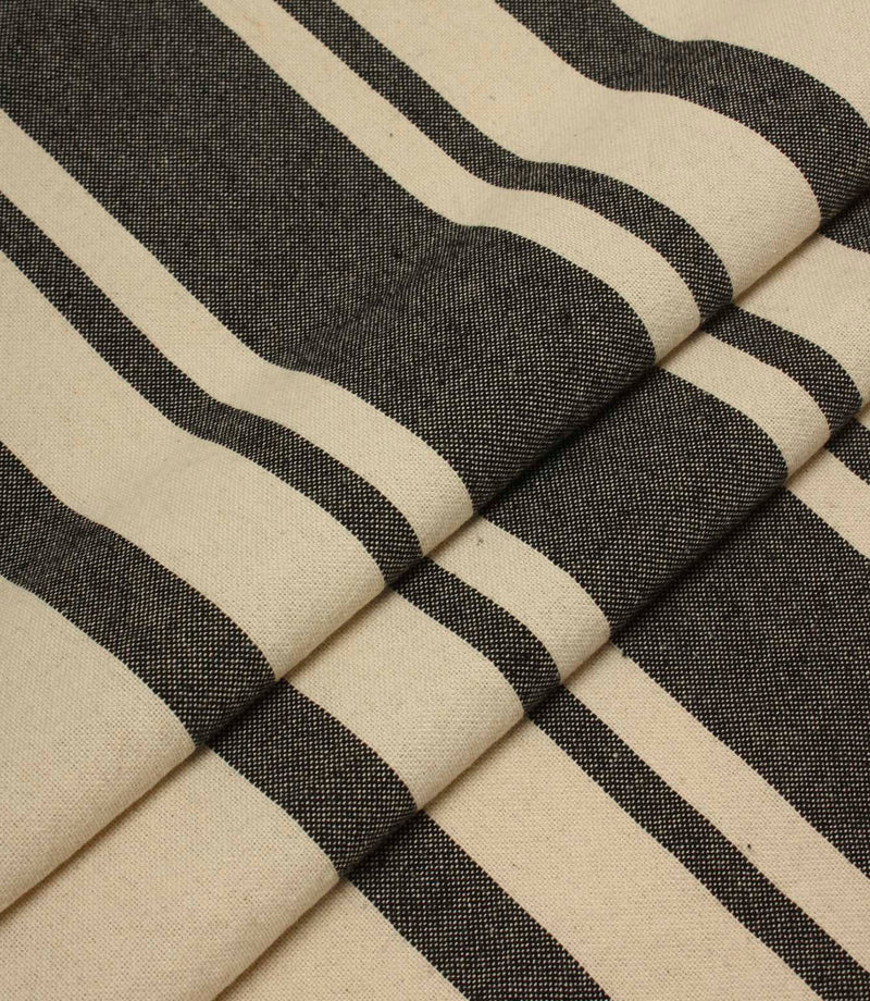 Folded striped upholstery fabric in cream and black tones with a soft drape and textured woven surface.