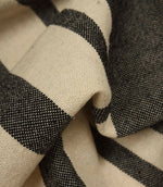 Detailed close-up of cream and black woven stripe fabric highlighting the texture and contrast within the weave.
