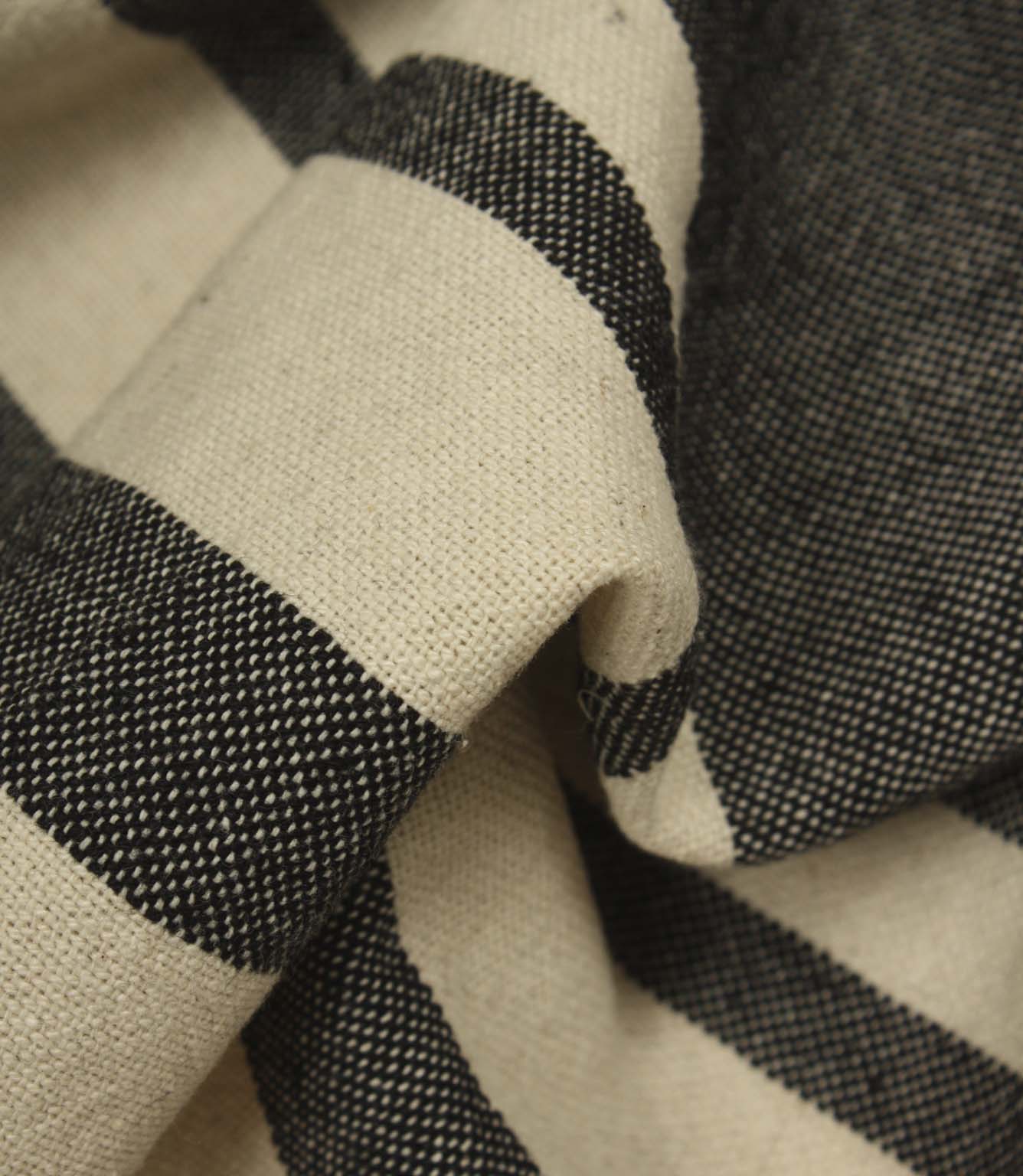 Detailed close-up of cream and black woven stripe fabric highlighting the texture and contrast within the weave.
