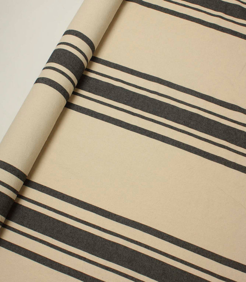 Rolled cream striped fabric with black stripe detailing, ideal for upholstery, curtains and interior décor applications.