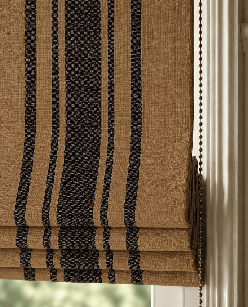 Brown and black striped roman blind against a white wall