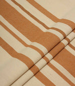 Folded cream and terracotta striped upholstery fabric with a soft drape and textured woven surface.