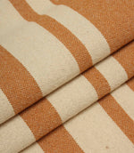 Gathered cream and terracotta striped fabric highlighting the bold stripe design and relaxed woven texture.