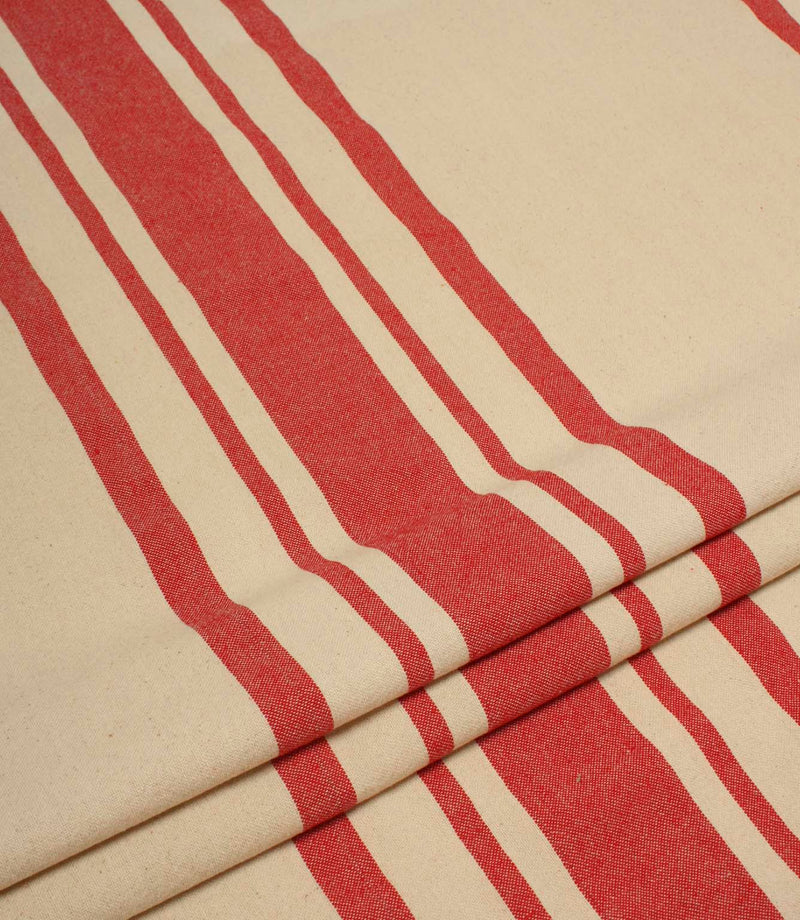Folded cream and red striped upholstery fabric showing the bold stripe pattern and soft woven drape.
