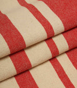 Detailed close-up of folded cream and red striped fabric with textured weave and contrasting stripe design.