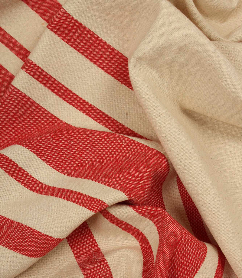 Gathered cream and red striped fabric highlighting the relaxed drape and woven texture of the material.