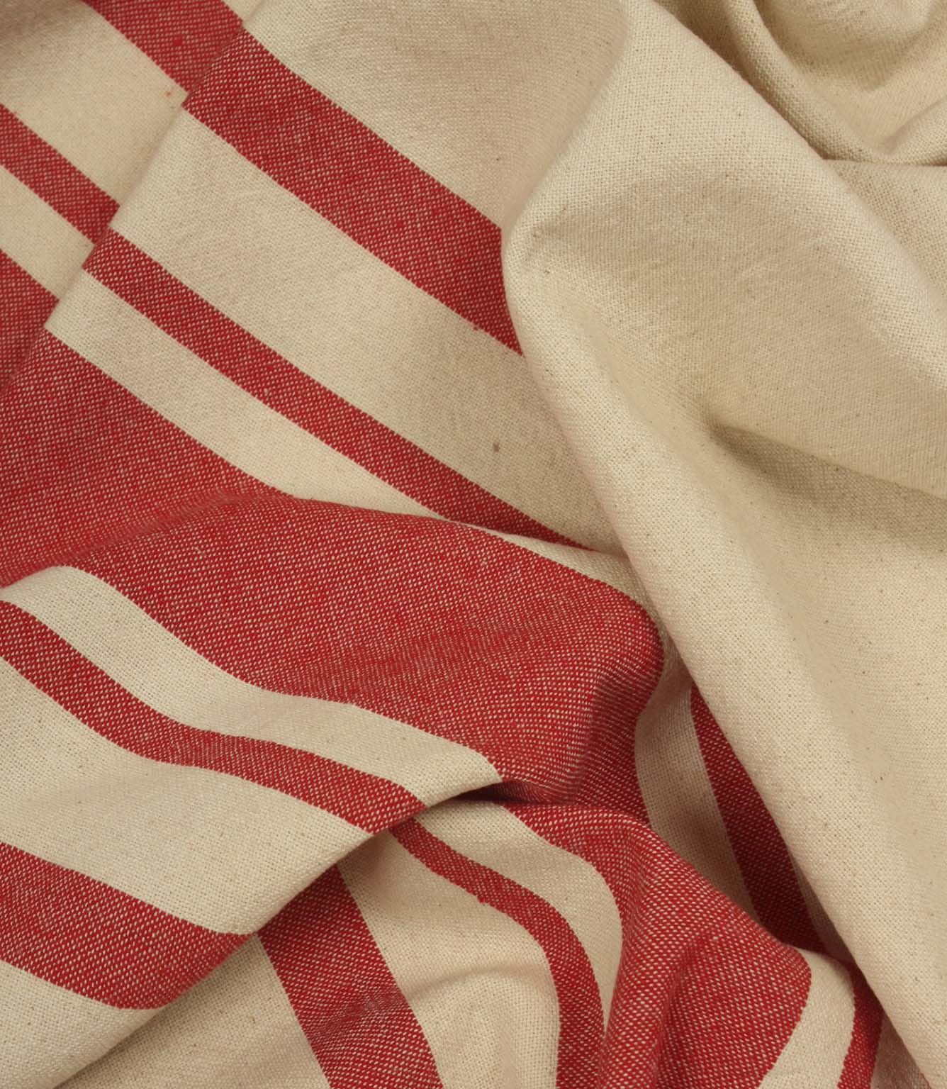 Gathered cream and red striped fabric highlighting the relaxed drape and woven texture of the material.