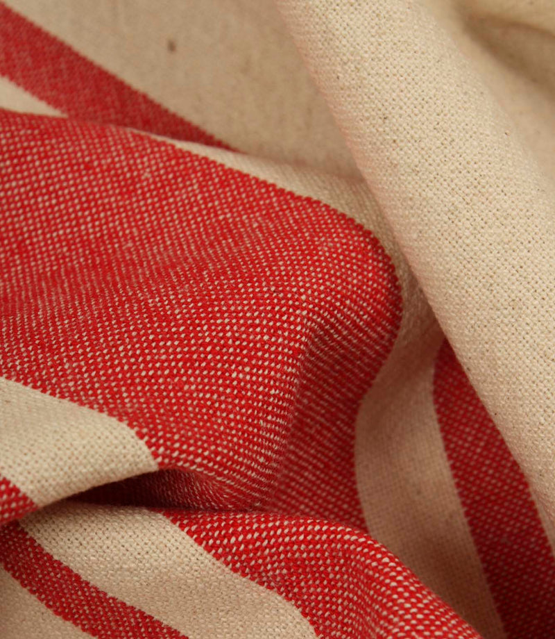 Macro close-up of cream and red woven stripe fabric showing the fine weave detail and soft texture.